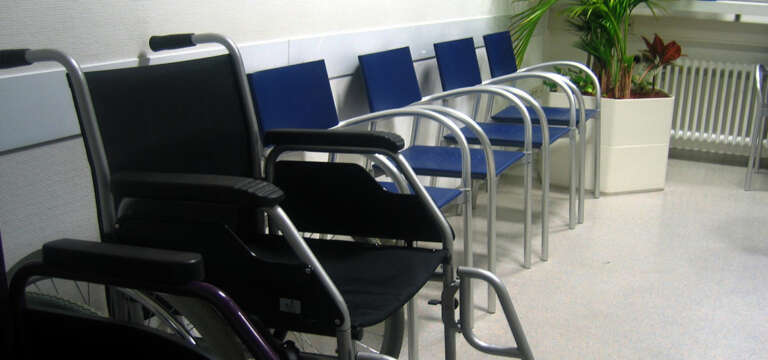 Wartezimmer: Stühle und ein Rollstuhl