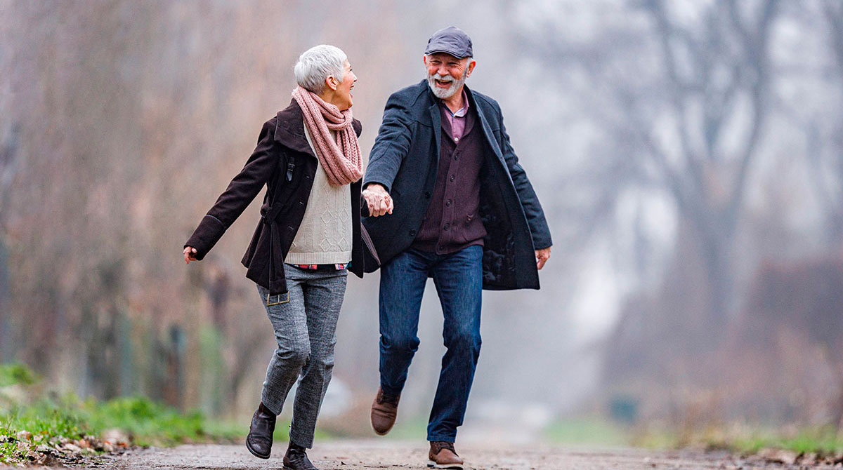 aktives fröhliches älteres Paar beim Spaziergang